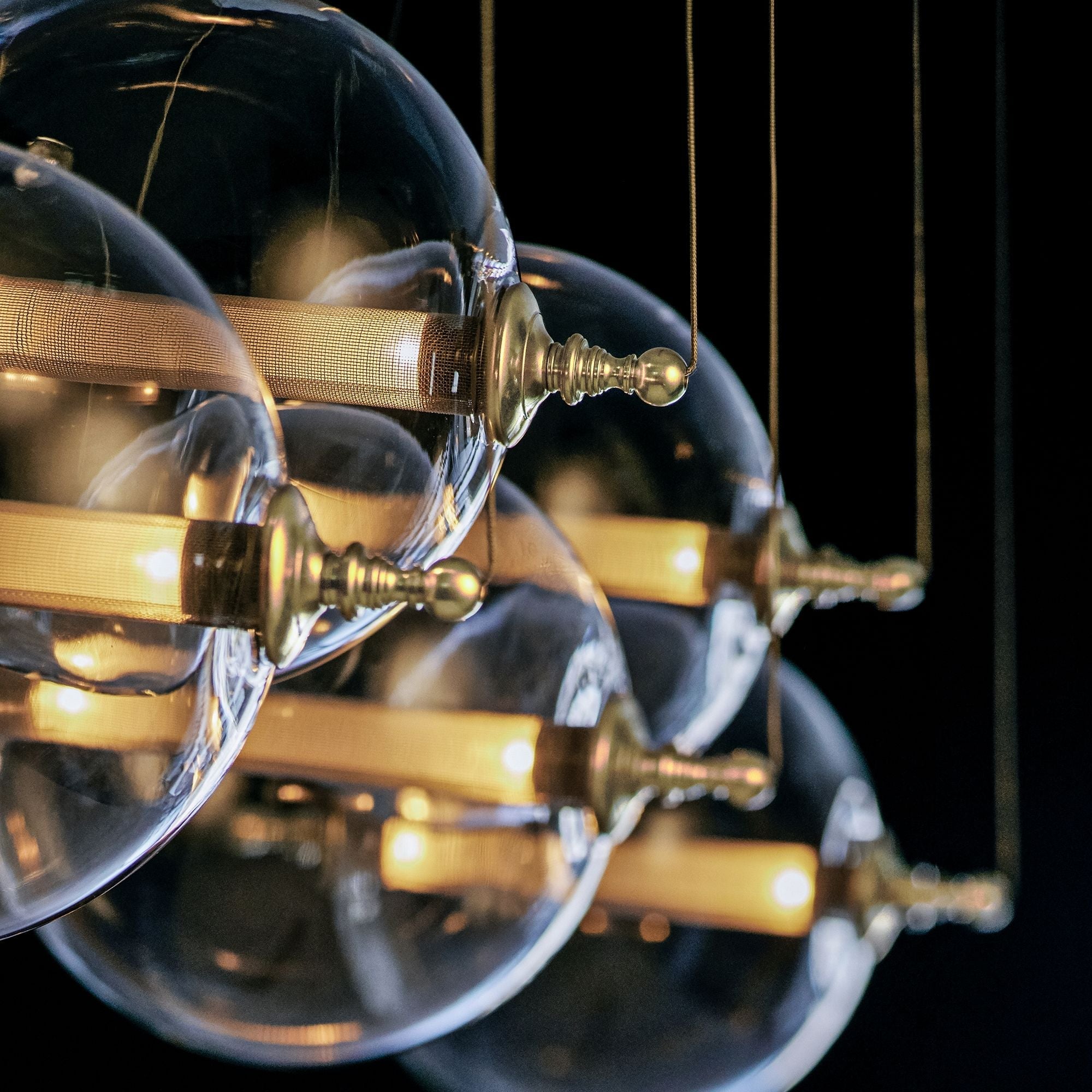 Close-up angle of Otto Sphere 57" Wide 5-Globe Black Pendant Chandelier showing form and material detail